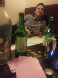 Zach & the remains of our evening - empty alcohol bottles and coins from a game we were playing